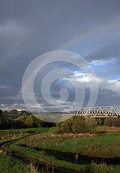 Rainbow after a thunderstorm. Spring in the Western Urals. Perm Krai, Kungur, the Trans-Siberian Railway bridge over the Iren Rive