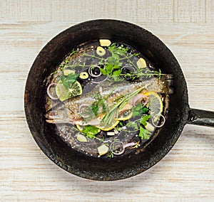 Rainbow Trout Fish in Frying Pan with Herbs and Spices