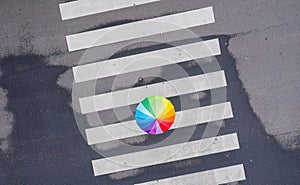 Rainbow umbrella on a pedestrian crosswalk - view from a drone