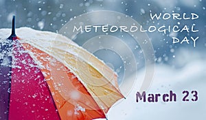 Rainbow umbrella under heavy snow in park. World meteorological day