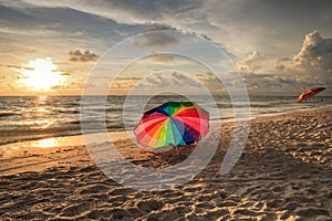 Rainbow umbrella on White sand at Delnor Wiggins State Park at sunset photo