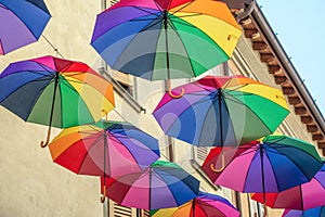 Rainbow umbrellas on blue sky background. Many colorful umbrellas, street decoration for festivals. Concept diversity