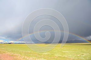 The rainbow under the dark clouds in Tibet