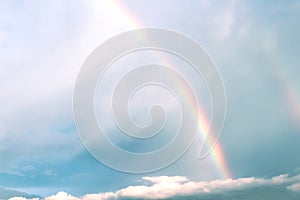 Rainbow on white cloud blue sky background after rain