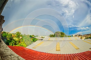 Rainbows on blue sky over the roof top
