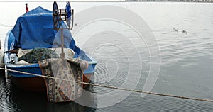 Raindrop falling and seagulls swimming on the sea water with fishing boat