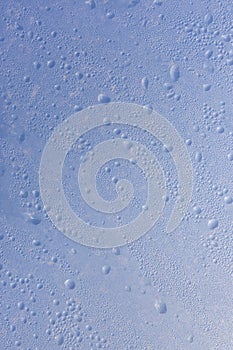 Raindrop texture on wet blue glass, closeup macro. The concept of the arrival of spring, autumn