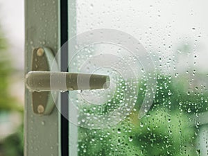 Raindrop on window Handle Blur tree background Rainy Season