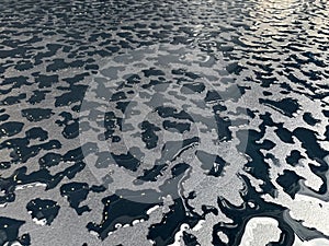 Raindrops on the black table surface that forms some abstract conceptual background