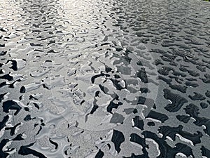 Raindrops on the black table surface that forms some abstract conceptual background