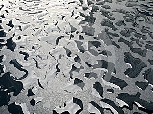 Raindrops on the black table surface that forms some abstract conceptual background