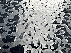 Raindrops on the black table surface that forms some abstract conceptual background