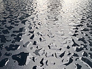 Raindrops on the black table surface that forms some abstract conceptual background