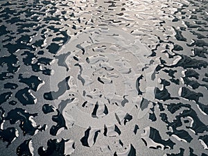 Raindrops on the black table surface that forms some abstract conceptual background