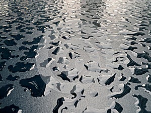 Raindrops on the black table surface that forms some abstract conceptual background