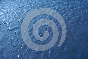 Raindrops on blue round plastic surface