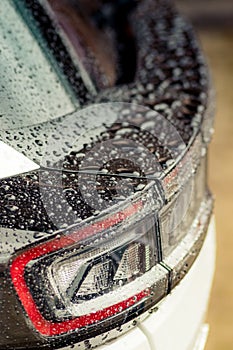 Raindrops on the car. Car element with raindrops close-up. Car rear glass with rain drops and frameless wiper blade closeup. Big