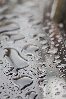 Raindrops on the car. Car element with raindrops close-up. Car rear glass with rain drops and frameless wiper blade closeup. Big