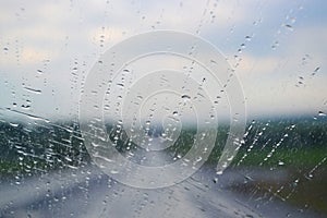 Road view through car window with rain drops, Driving in rain.