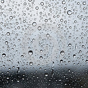 Raindrops cover a glass surface with