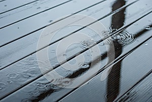 Raindrops fall on a wooden terrace