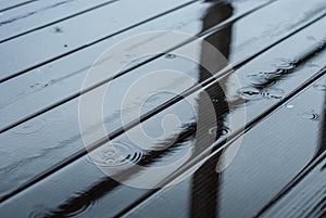 Raindrops fall on a wooden terrace