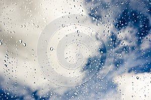 Raindrops on glass with blue sky in the background