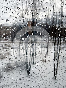 Raindrops on the glass, rain in the new year, rain with snow, wet weather, rainy weather, depression, gray sky