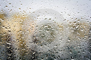 Raindrops on glass, window background view of buildings out of focus