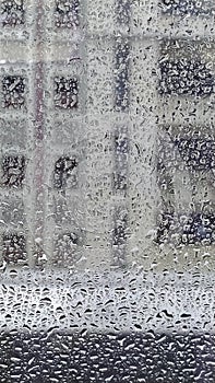 Raindrops on the glass window of the building background
