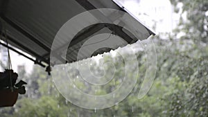 raindrops hit the eaves above the window and flow down