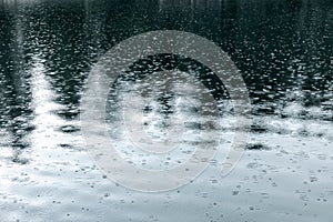 Raindrops rippling on lake surface during rain