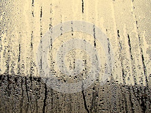 Raindrops texture on the glass window in the room. Outside the w