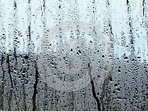 Raindrops texture on the glass window in the room. Outside the w