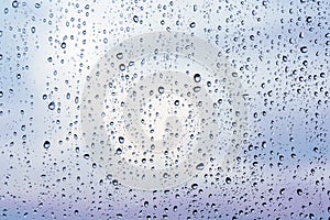 Raindrops on window glass, cloudy weather, background, texture