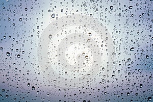 Raindrops on window glass, cloudy weather, background, texture