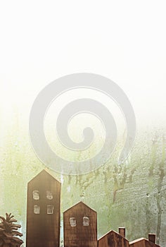 Raindrops on window glass and house sculpture wood background