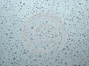 Raindrops on the window glass in opposite light