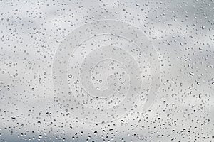 Raindrops on window glass, selective focus, rainy city background, wet glass, texture of raindrops