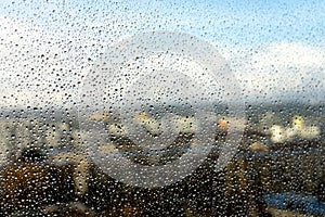 Raindrops on the window. Landscape through the humid glass.