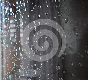 Raindrops on a window pane. Drops of water on a metal surface, on a window pane, Window in a house in rainy time