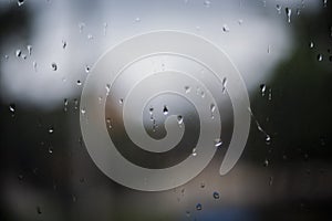 raindrops on a window. Rainy window at night. dark blue wet, drops of water rain on glass background. concept of autumn weather