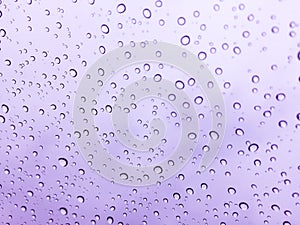 The raindrops on the windscreen or windshield or car glass. View from the inside of the car with a grey sky background. Adjust the