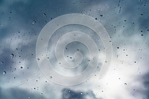 Raindrops on the windshield; in the bright light managing to break through dark, storm clouds, California