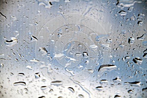 Raindrops on the windshield of a car against the sky