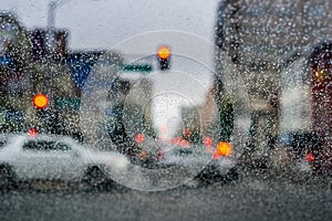 Raindrops on the windshield on a rainy day, blurred traffic light background, San Francisco, California