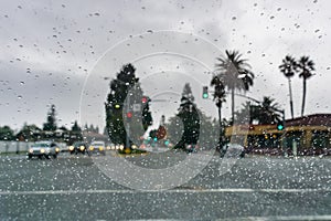 Raindrops on the windshield on a rainy day, traffic light background