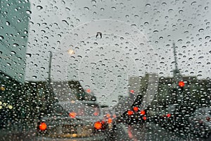 Raindrops on the windshield on a rainy day, traffic light background, San Francisco, California