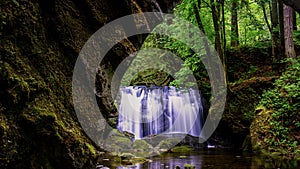 Washington State waterfall with mossy rocks and old rock bridge