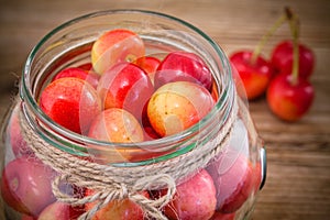 Rainier Cherries in glass on wooden background